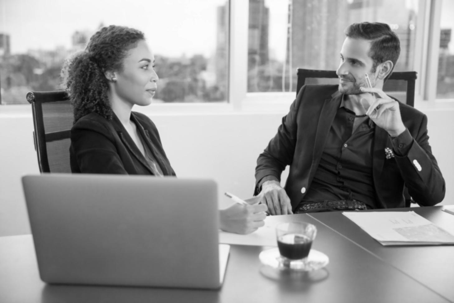 Financial planning session with detailed budget analysis documents spread across a conference table